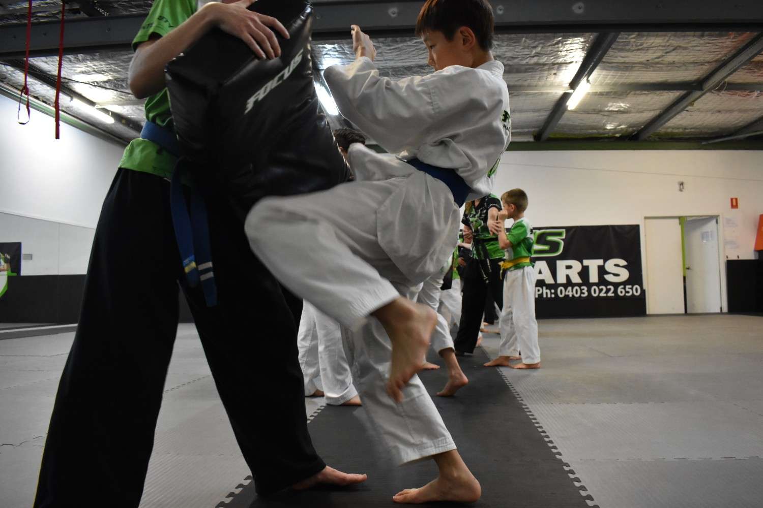 kids showing off martial arts moves during a class