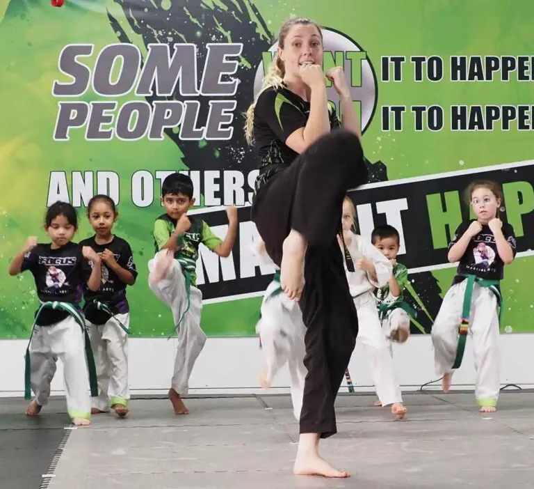 Kids following instructor movements during a Brazilian jiu jitsu class inside a martial arts academy