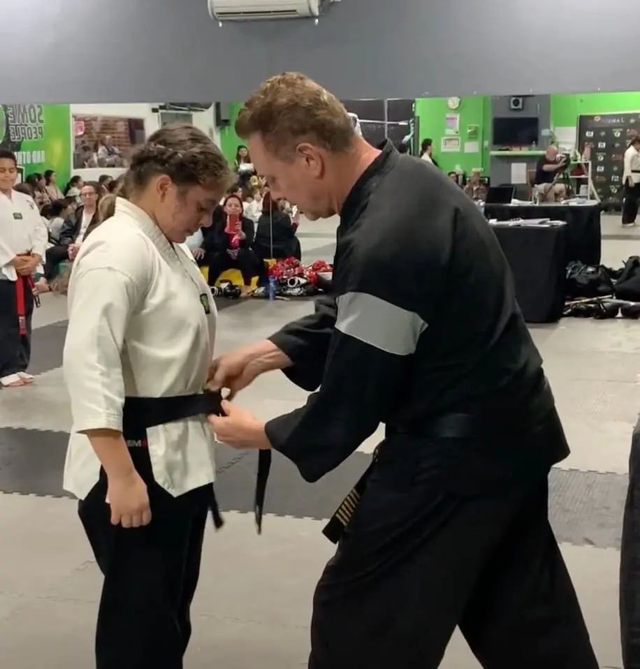 Martial arts belt ceremony highlighting the progression and achievement of students in adult and kids' BJJ lessons.