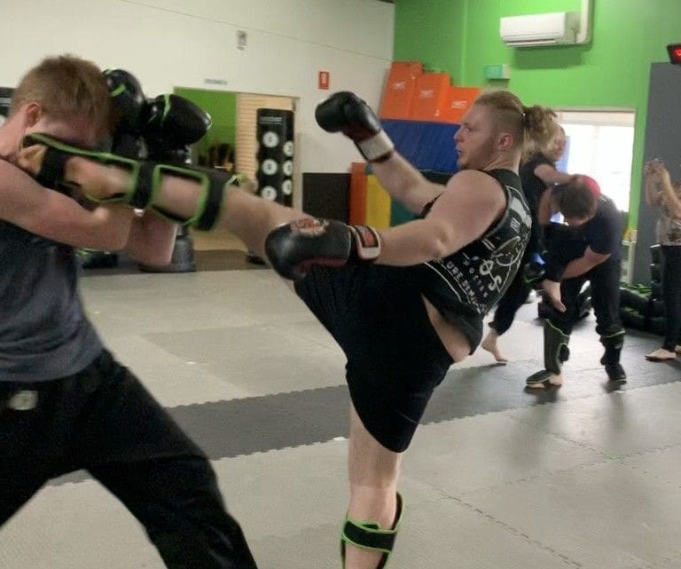 student practicing high kicks for adult taekwondo class
