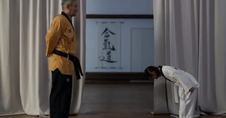 Young student bowing to instructor during karate etiquette