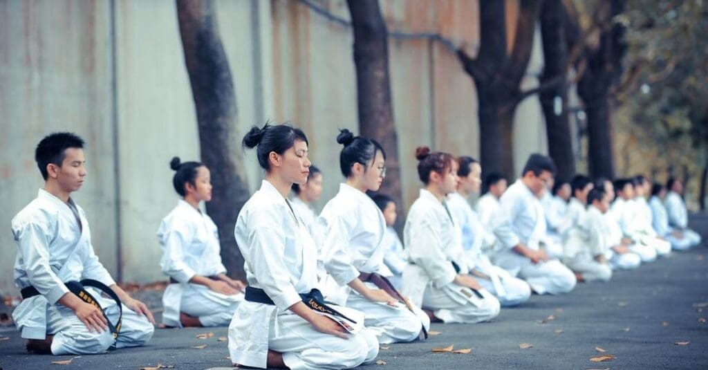 Karate students meditating outdoors during karate etiquette practice