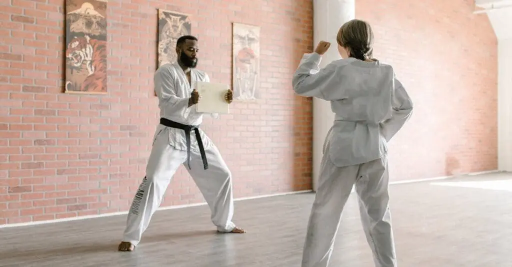 Student practicing strikes with instructor during karate basics training