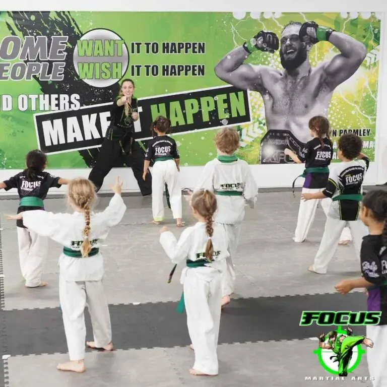 Young students following an instructor's punch during a youth martial arts class representing the Brazilian Jiu-Jitsu belt system