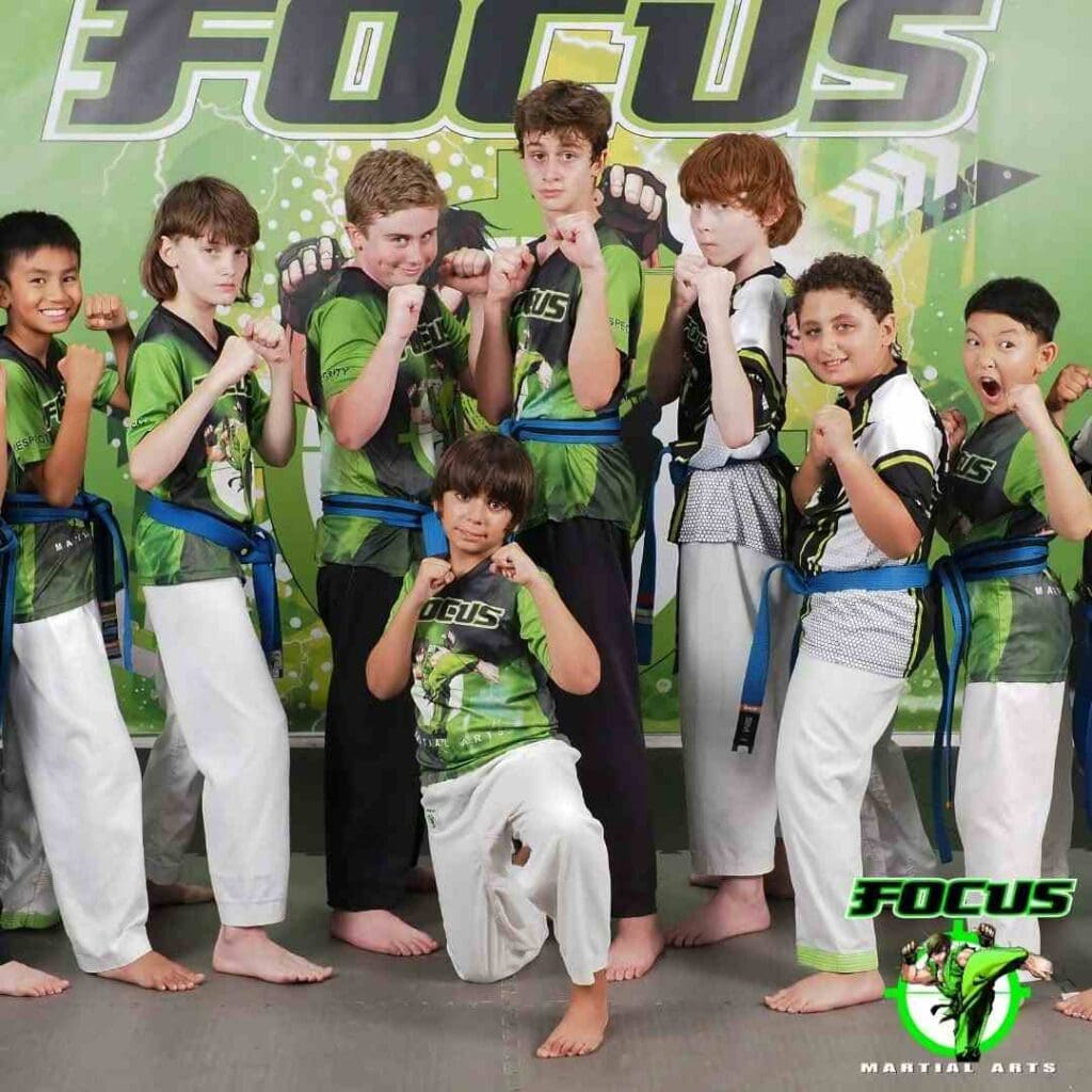 A group of young martial artists posing in fighting stances during a group photo session representing the Brazilian Jiu-Jitsu belt system